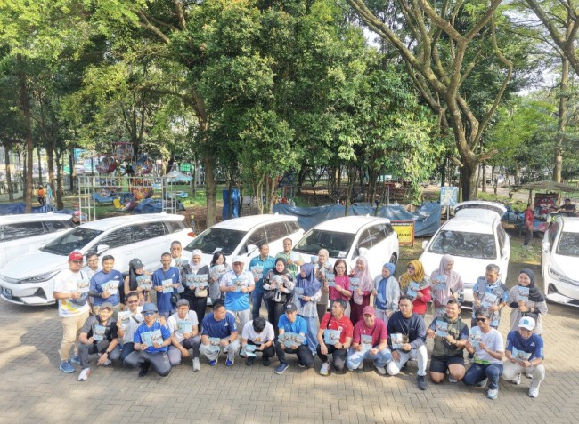 Foto bersama para karyawan PLN UP3 Malang dengan latar belakang kendaraan listrik saat konvoi. (Foto: istimewa)