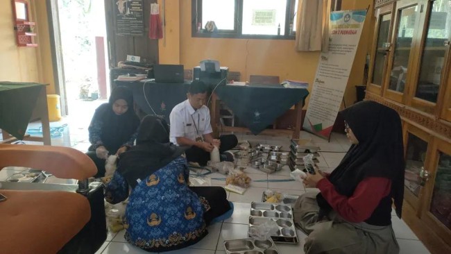 Potret para guru membungkus makanan MBG. (Foto: Threads)